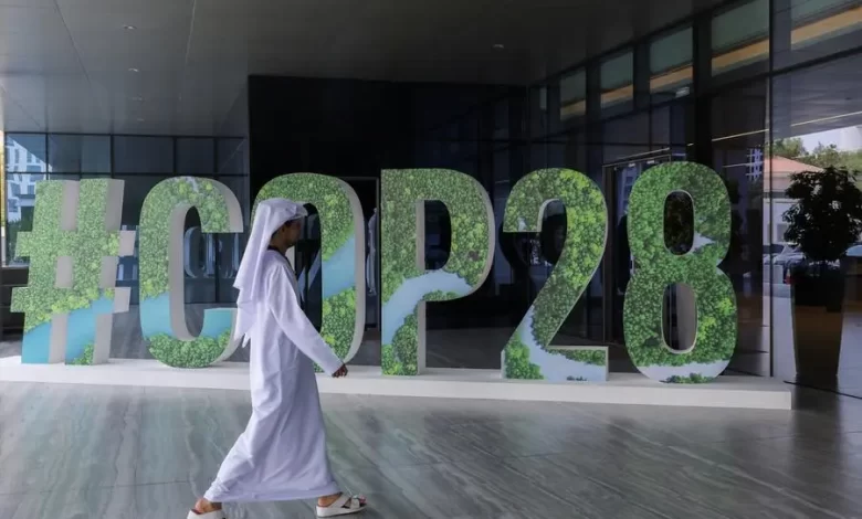 A person walks past a "#COP28" sign during The Changemaker Majlis, a one-day CEO-level thought leadership workshop focused on climate action, in Abu Dhabi, United Arab Emirates, October 1, 2023. REUTERS/Amr Alfiky