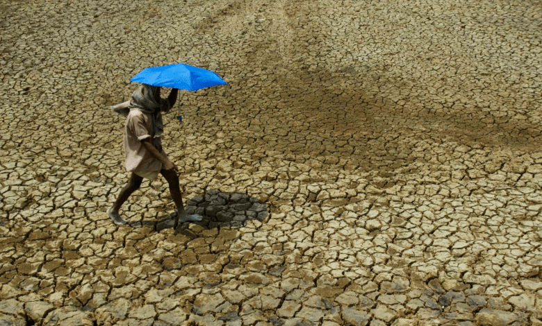 Climate Loss and Damages COP28 - FILE - A villager holding umbrella to protect himself from sun, walks over parched land on the outskirts of Bhubaneswar, India on May 2, 2009. Tense negotiations at the final meeting on a climate-related loss and damages fund — an international fund to help poor countries hit hard by a warming planet — ended Saturday, Nov. 4, 2023, in Abu Dhabi, with participants agreeing that the World Bank would temporarily host the fund for the next four years.(AP Photo/Biswaranjan Rout, File)