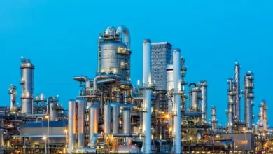 A large, modern petrochemical plant at dusk in industrial district near Rotterdam, Netherlands, Benelux, Europe. Distillation towers and other installations are visible against blue sky. 50 megapixel image taken with Canon EOS 5Ds, digital blending technique, long exposure with tripod.