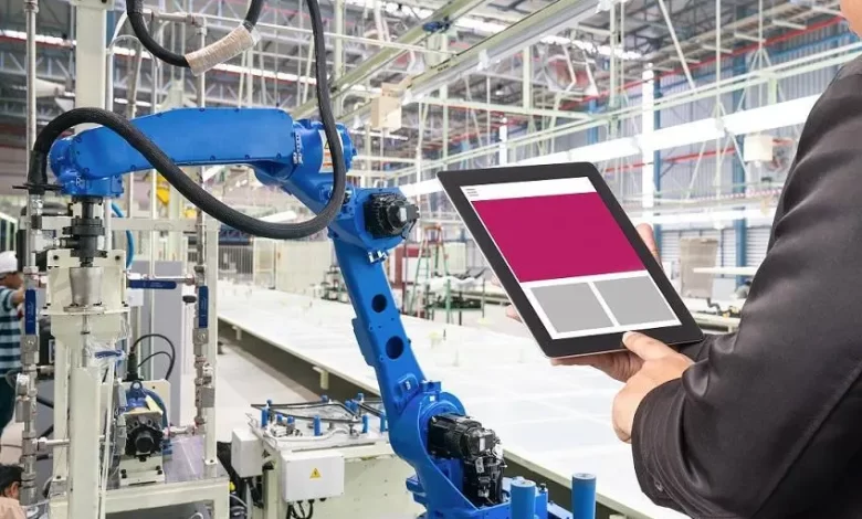Engineer hand using tablet, heavy automation robot arm machine in smart factory industrial with tablet real time monitoring system application. Industry 4th iot concept. Getty Images/Getty Images Source: Zawya.com