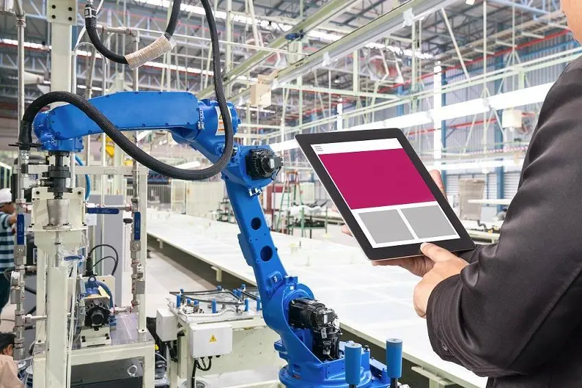 Engineer hand using tablet, heavy automation robot arm machine in smart factory industrial with tablet real time monitoring system application. Industry 4th iot concept. Getty Images/Getty Images Source: Zawya.com