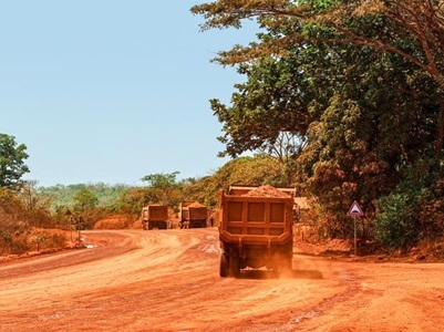 Trucks transporting bauxite along a mining hauling road in Guinea. Credit: Genevieve Campbell